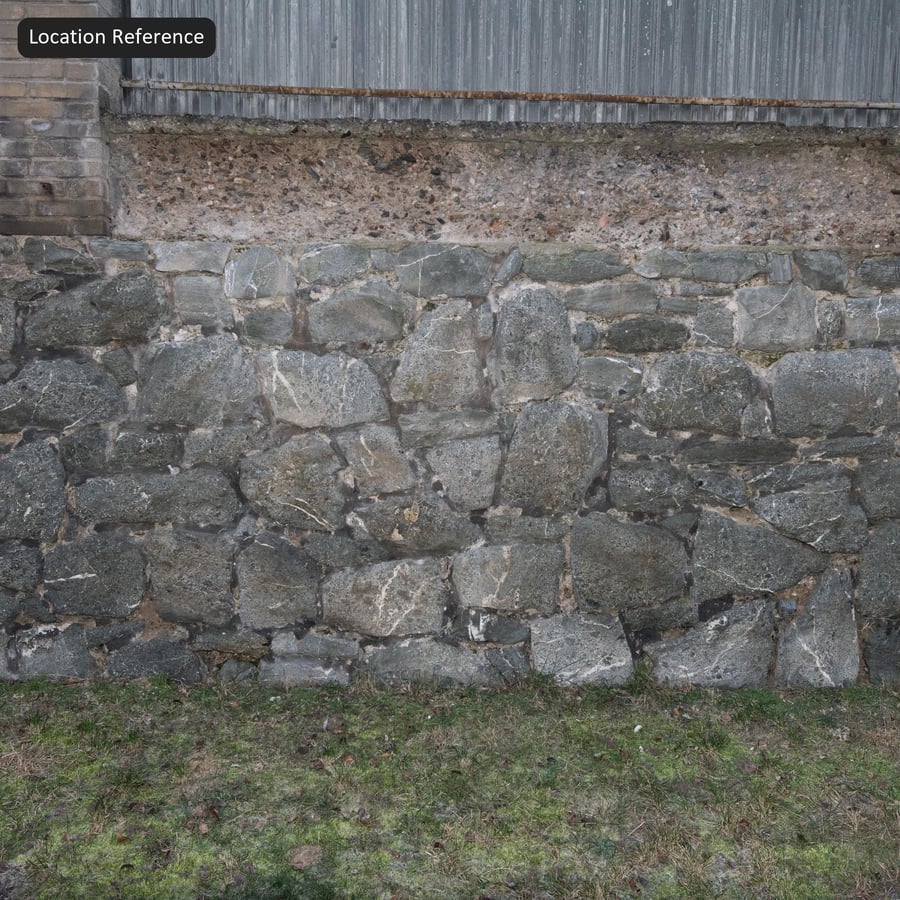Textura de muro de piedra de escombros de basalto cubierto de líquenes