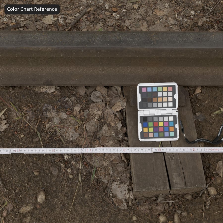 Carris de comboio afundados em textura de terra e gravilha, castanho