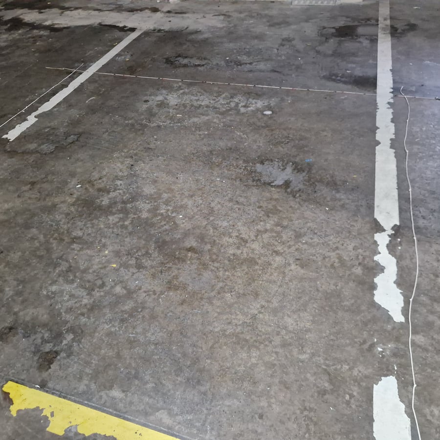 Textura da baía do parque de estacionamento em betão gasto