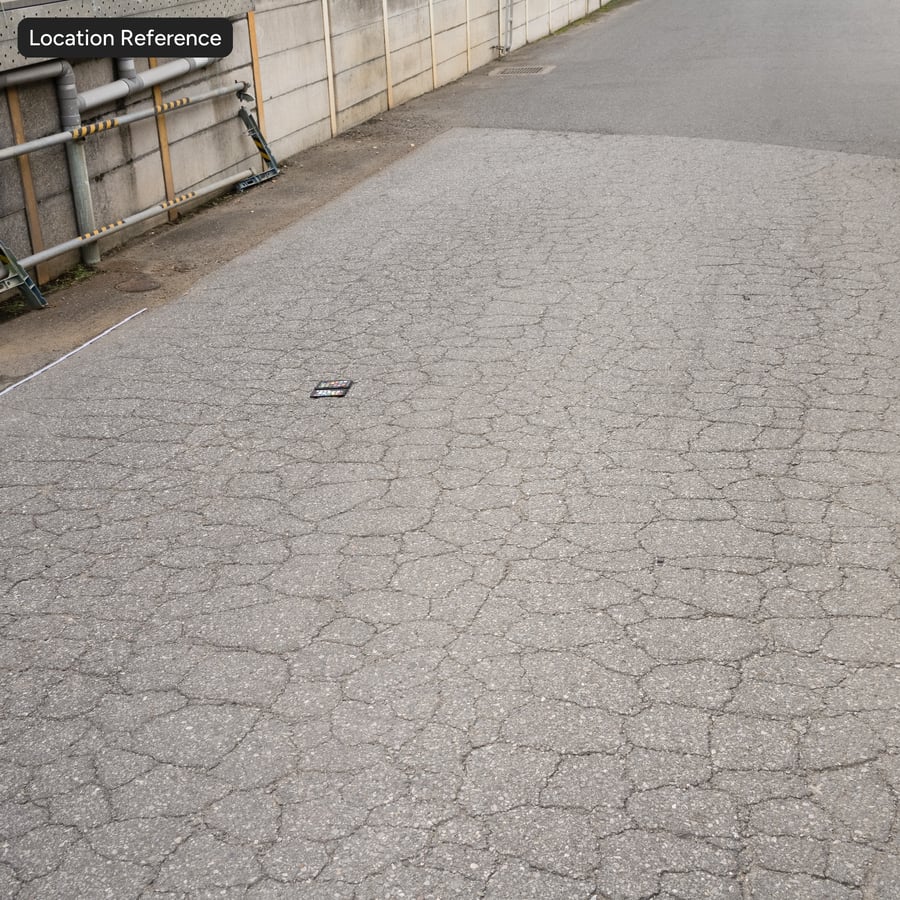 Rissige, raue Asphalt-Textur mit Gesteinskörnung